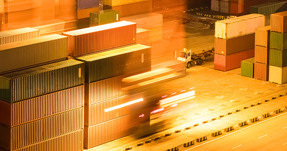 Frachtcontainer in Logistikzentrum, nächtliche Szene mit Lichteffekten und Fahrzeugbewegung