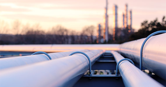 Nahaufnahme von Rohrleitungen, die zu einer industriellen Anlage führen