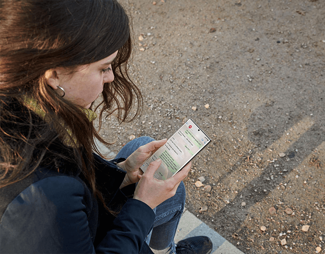 Eine junge Frau liest Nachrichten auf ihrem Smartphone. Eine junge Frau liest Nachrichten auf ihrem Smartphone.