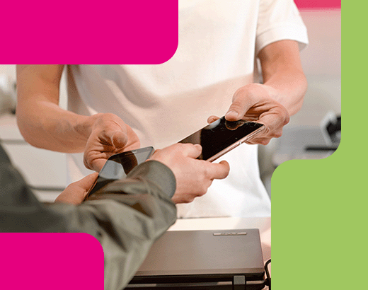 Wundertüte Zwei Personen tauschen ein Smartphone an einem Tresen in einem Technik-Shop aus.